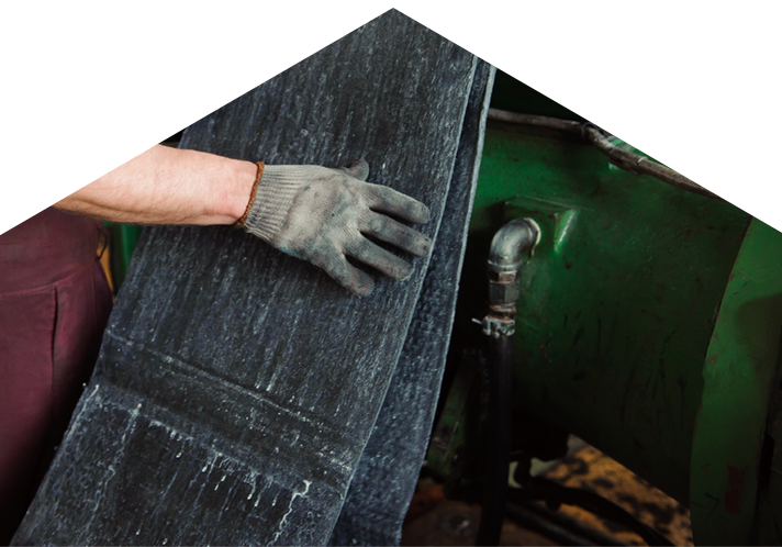 Person with gloved hand touching sheets of rubber